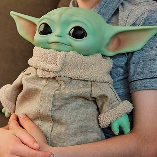 Baby Yoda Boneco Pelúcia - Star Wars - The Mandalorian 28 cm sendo segurado no colo de pessoa