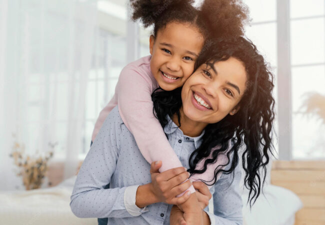 Mãe e filha abraçadas sorrindo e olhando para a foto